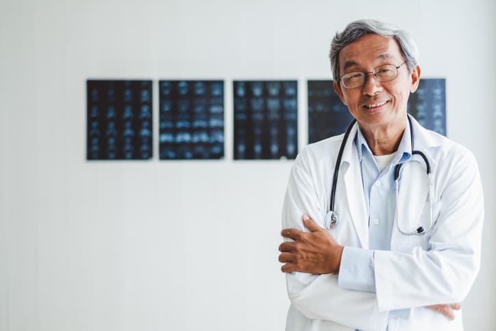 Asian doctor standing in front of xrays