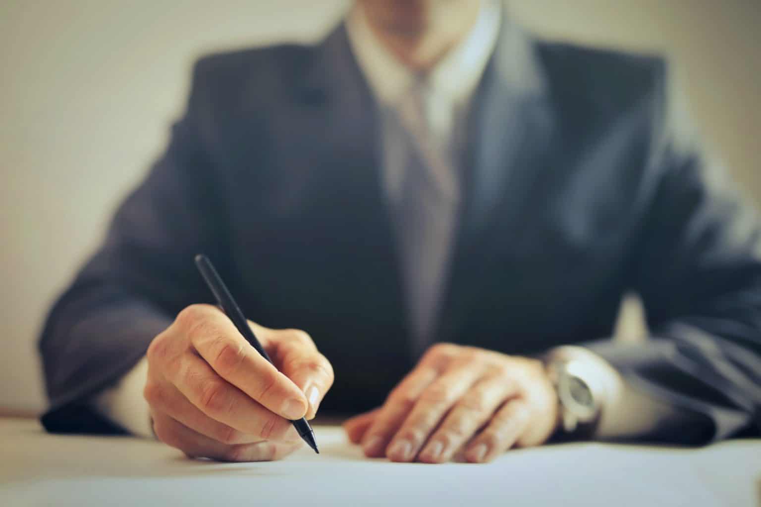 man writing in suit