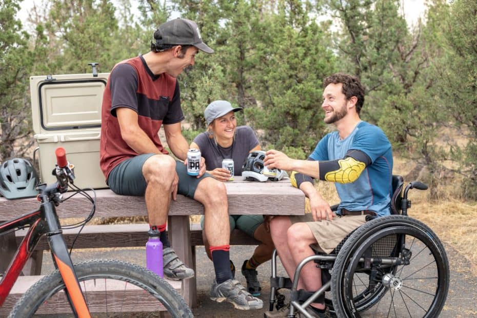 man in a wheelchair in the woods with friends
