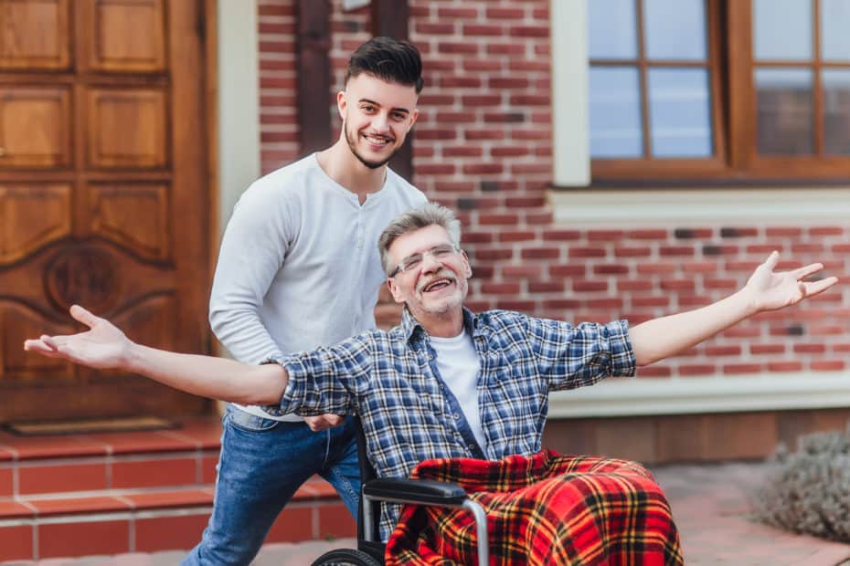 Senior father in wheelchair and young son on a walk. SoDH