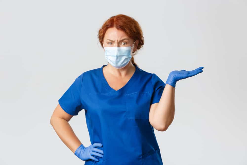 confused-skeptical-female-doctor-dentist-scrubs-face-mask-gloves-shrugging-pointing-right-frowning-disappointed